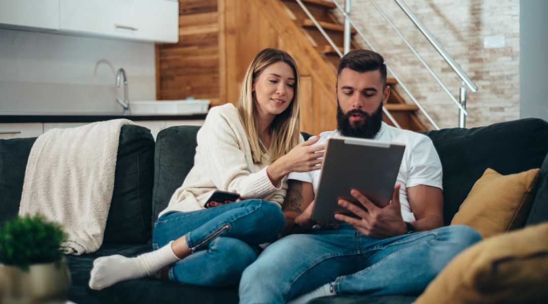 Couple on couch looking at an ipad