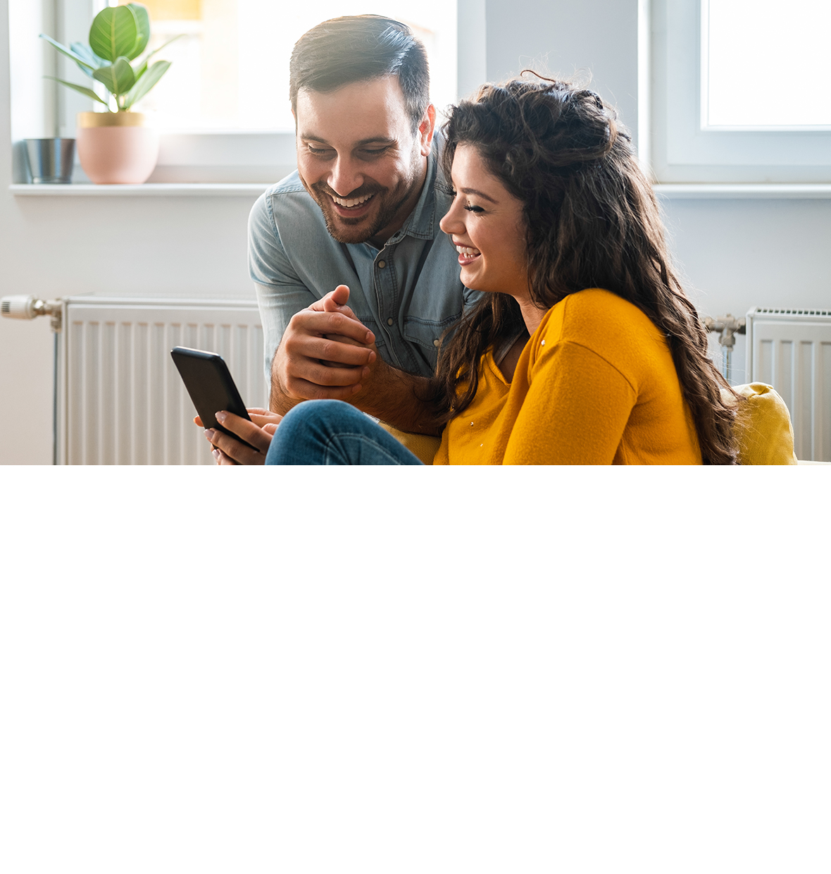 girl smiling down at her laptop with a man